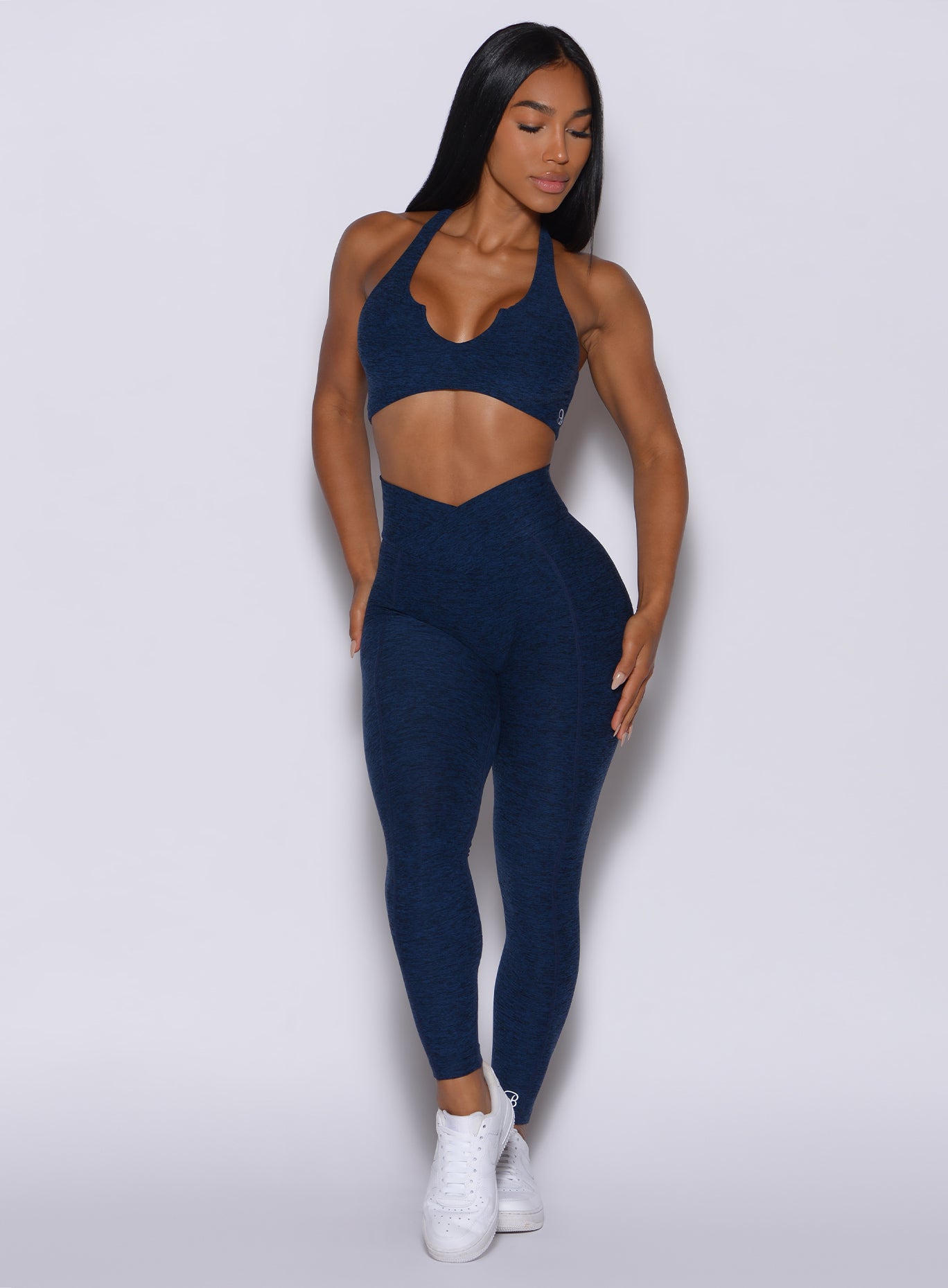 front profile view of a model in our Brazilian Contour Leggings in sapphire blue color and a matching bra