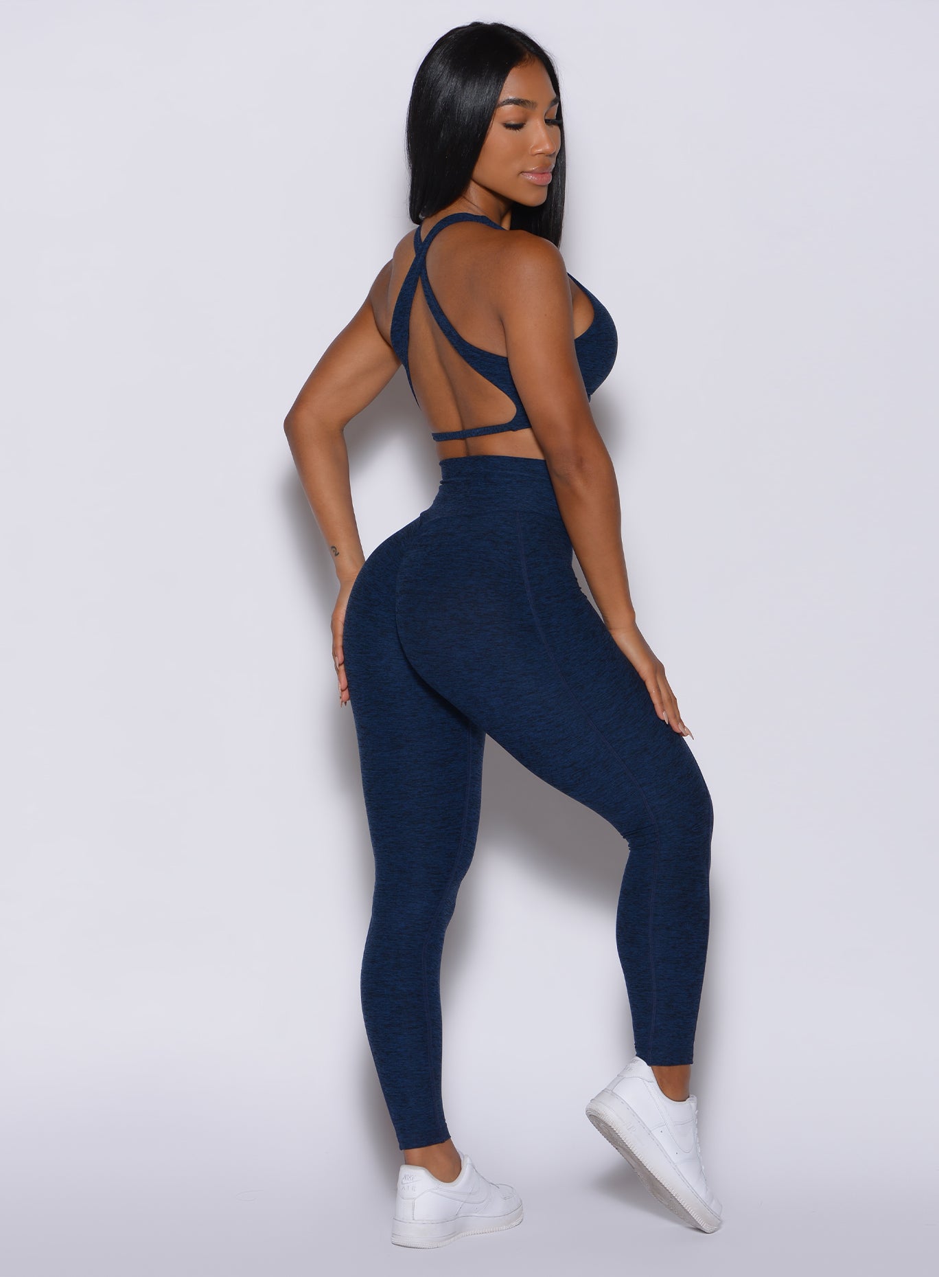 Right side profile view of a model in our Brazilian Contour Leggings in sapphire blue color and a matching bra