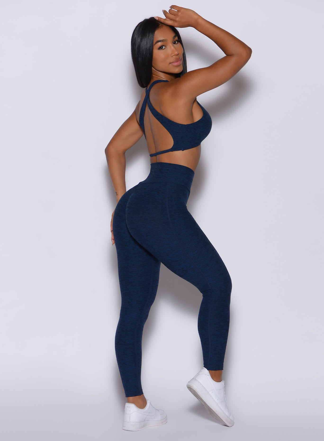 Right profile view of a model in our Brazilian Contour Leggings in sapphire blue color and a matching ace sports bra