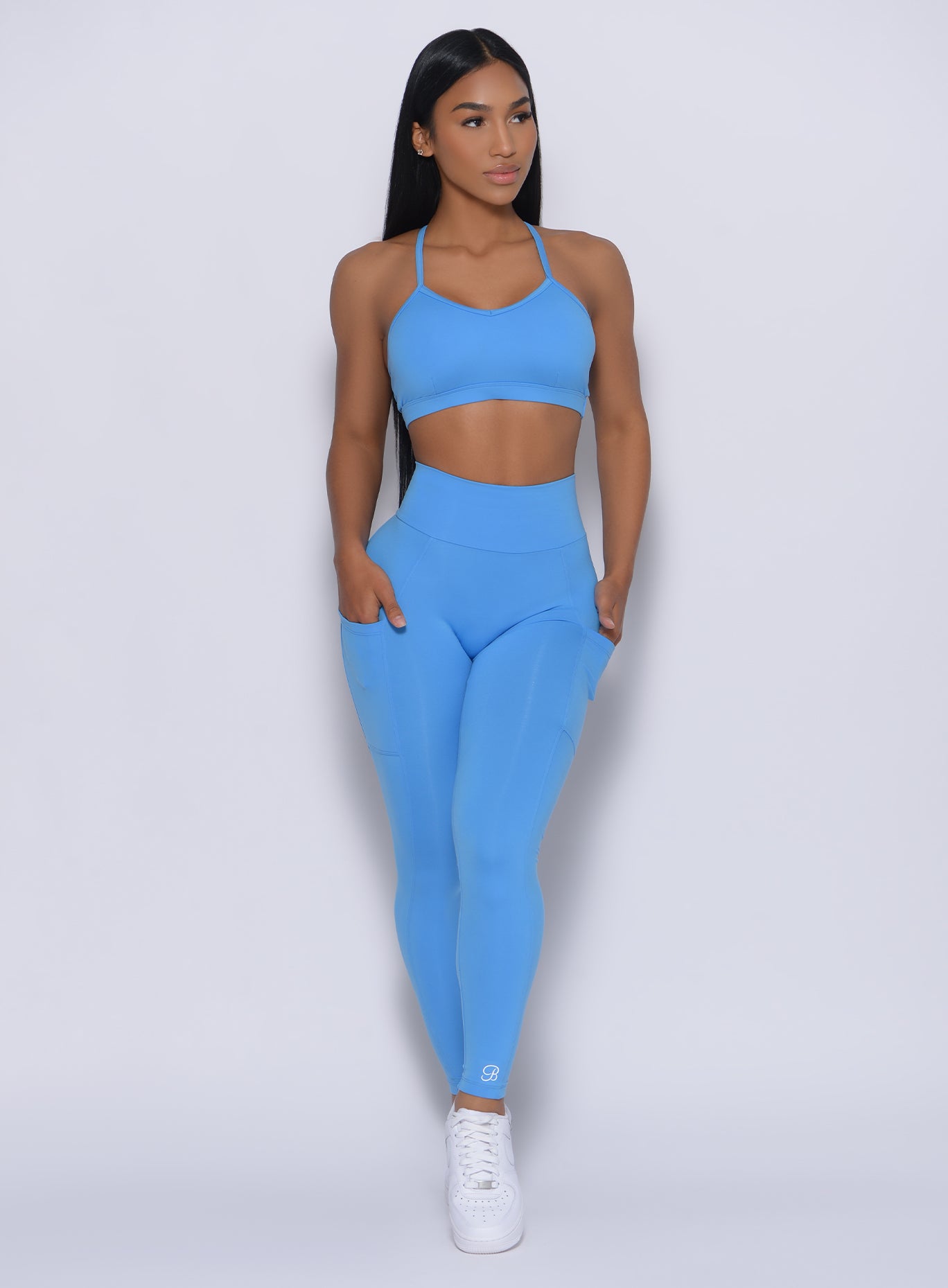 Front profile view of the model in our curves leggings in blazing blue color and a matching bra