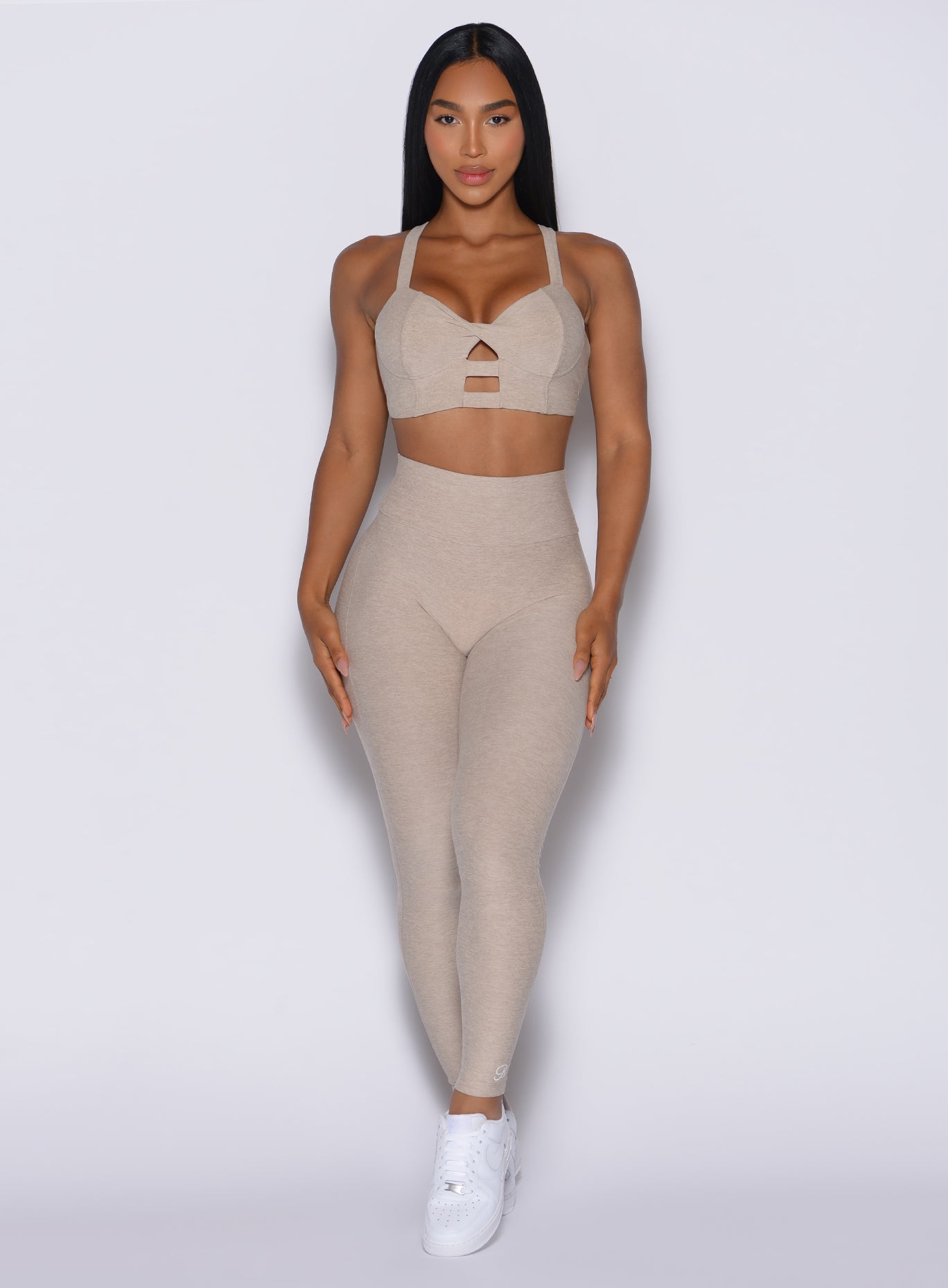 Model facing forward wearing our Movement Leggings in Taupe color and a matching Sports Bra