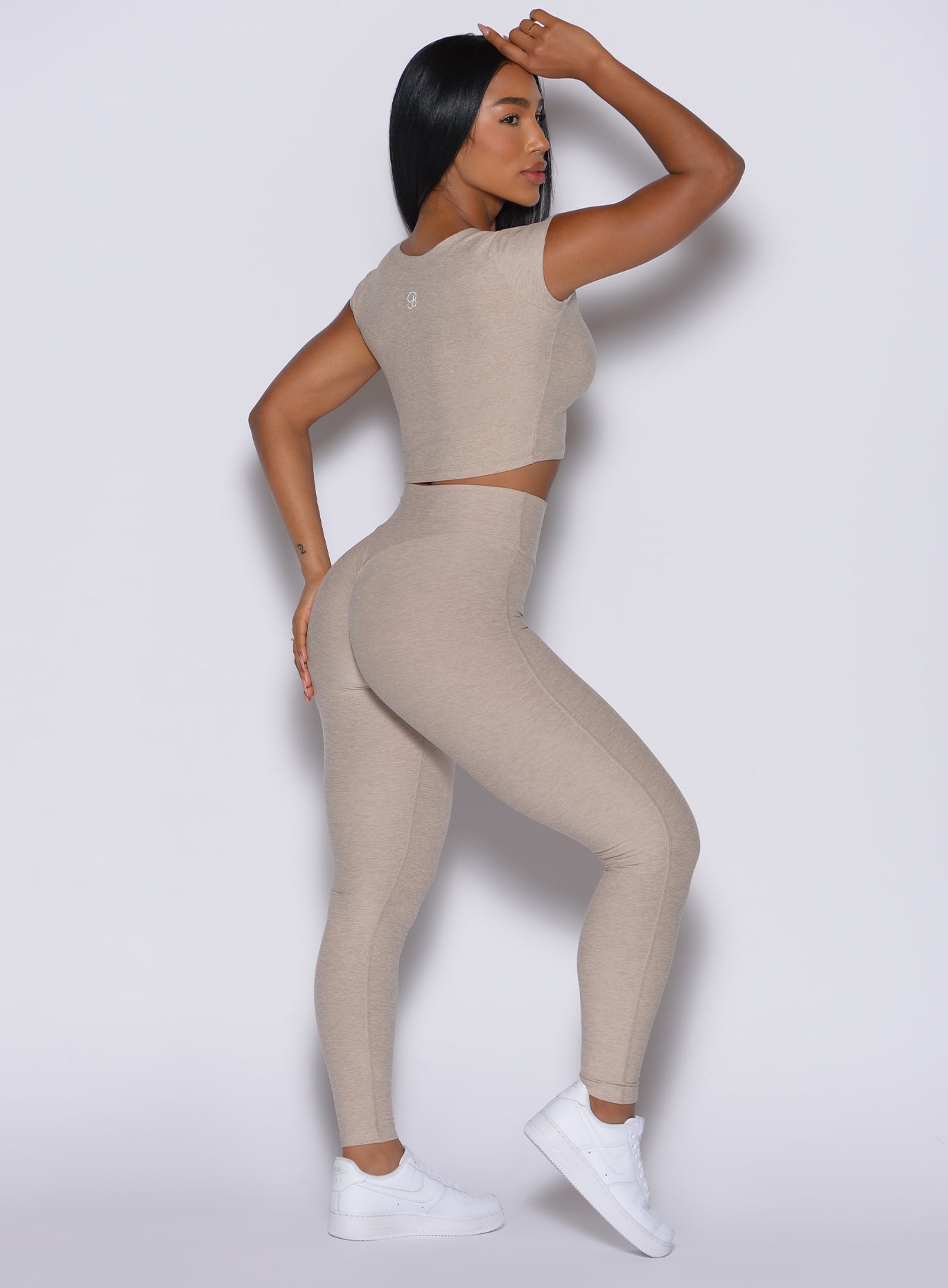 Right side profile view of a model wearing our Movement Leggings in Taupe color and a matching Tee