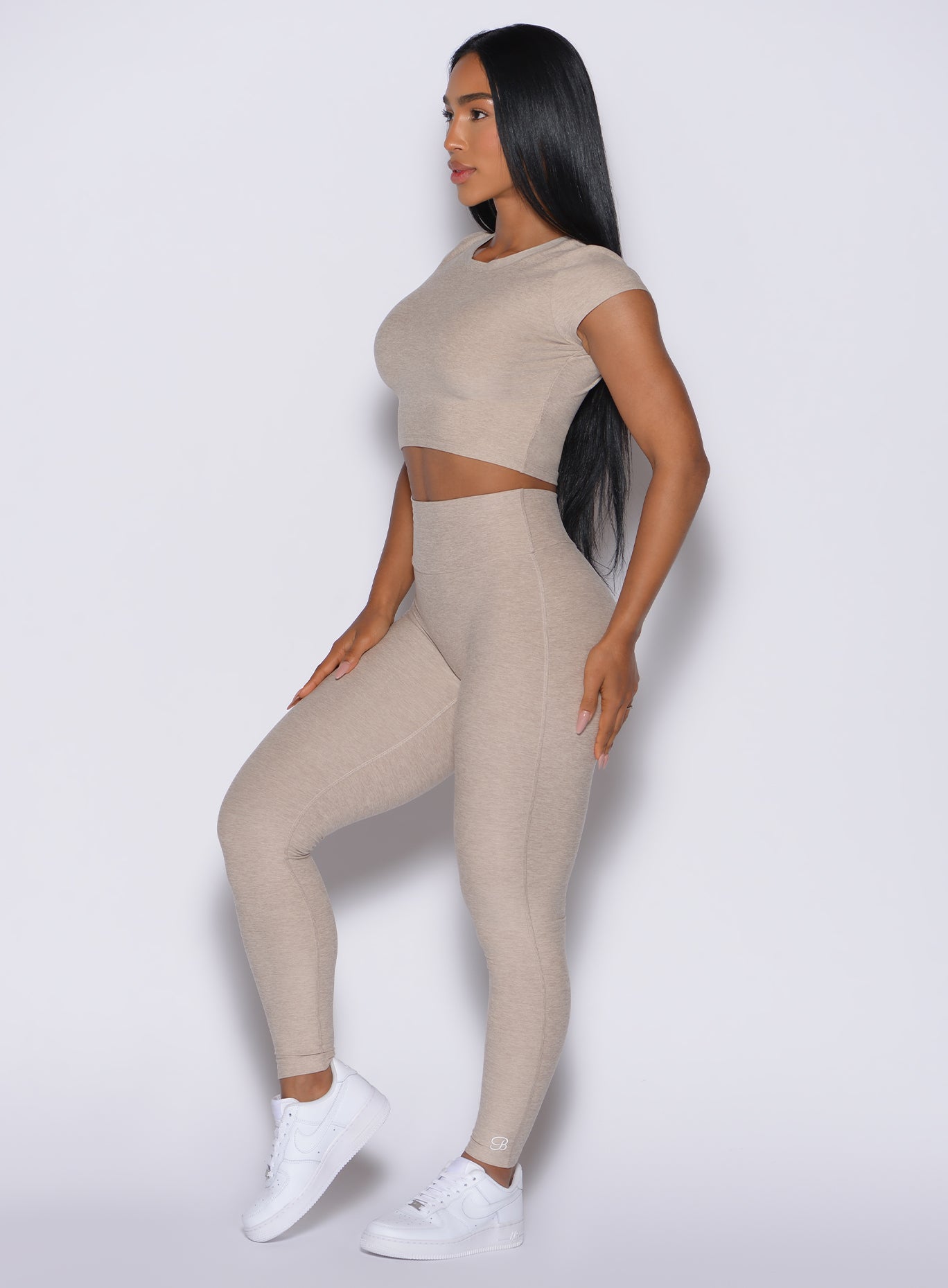 Right side view of a model in our Movement Leggings in Taupe color and a matching Tee