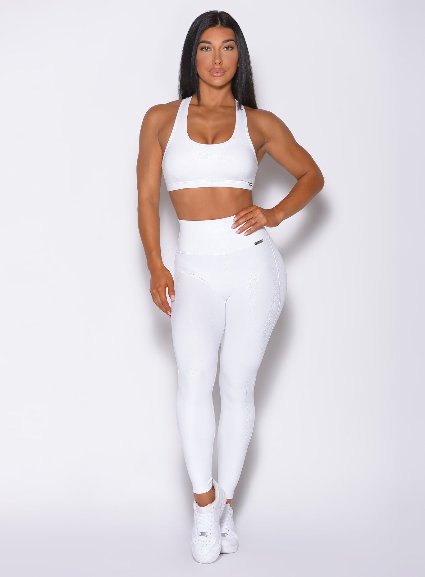 Model facing forward wearing our shine leggings set in white python color