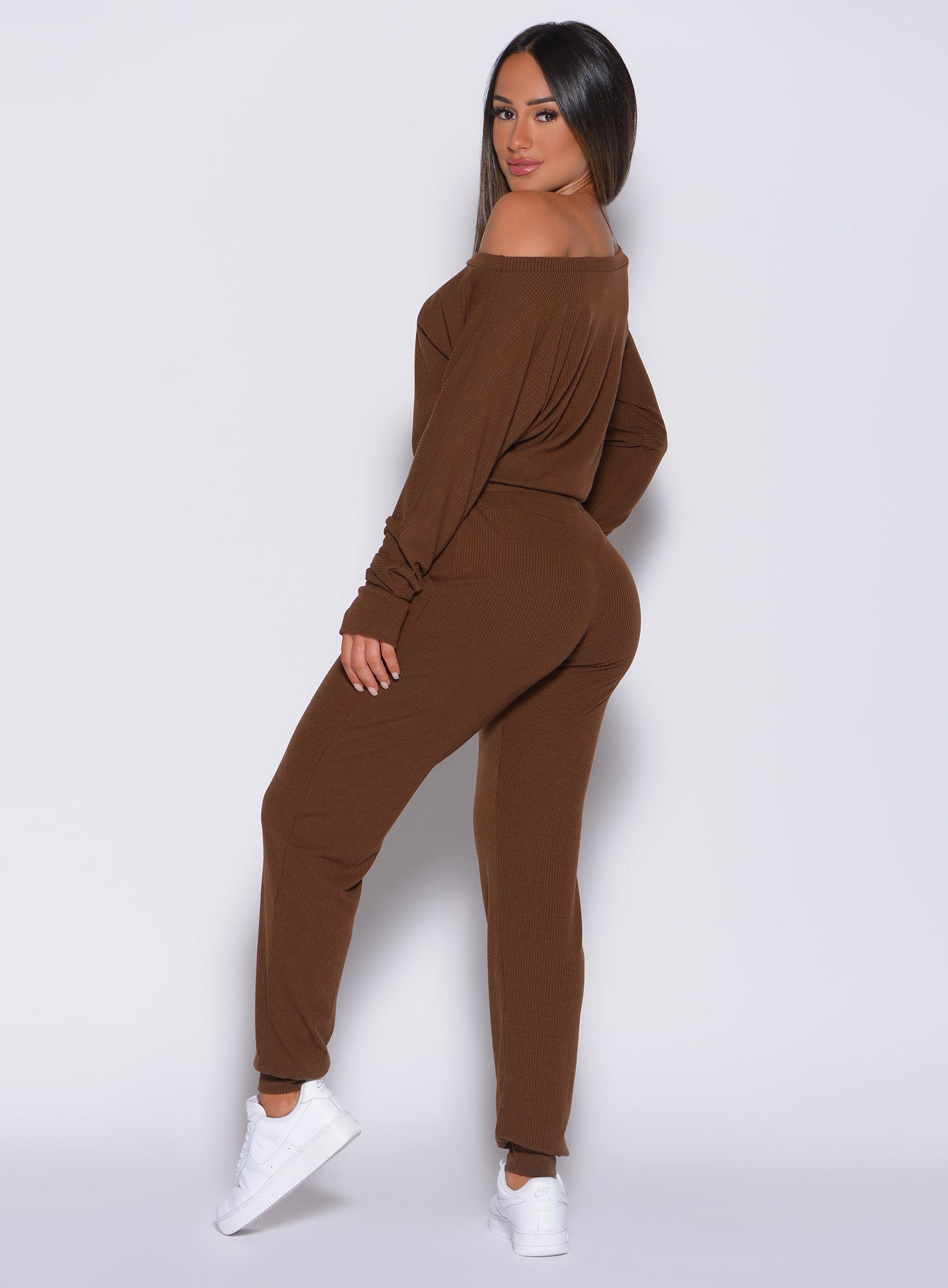 Left side profile view of a model in our rib jumpsuit in expresso color