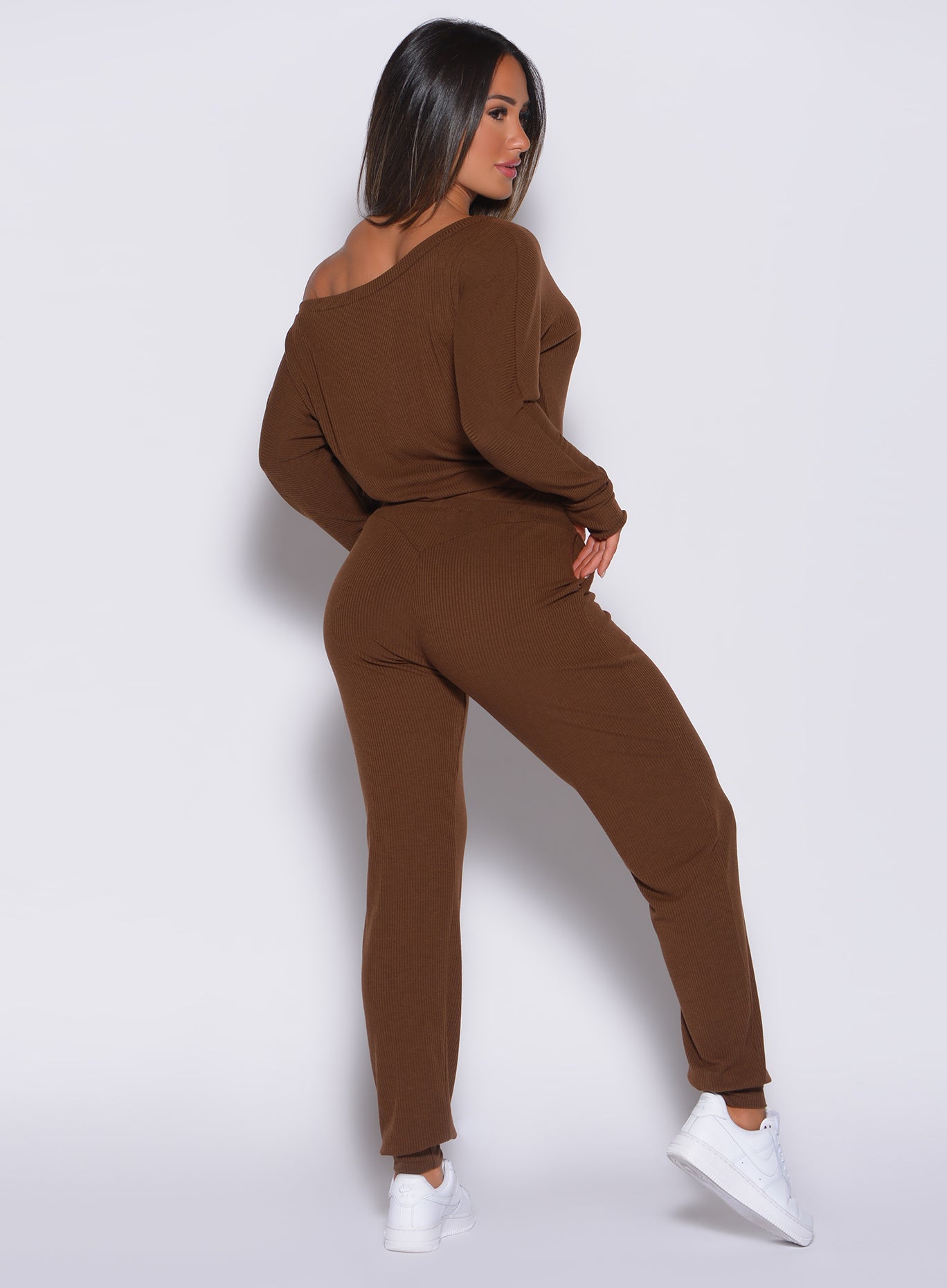 Back profile view of a model in our rib jumpsuit in expresso color