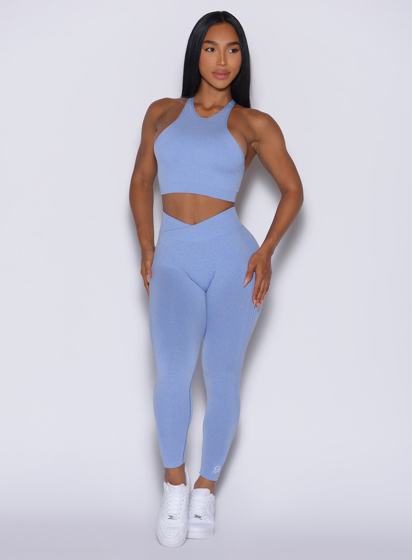 Model facing forward wearing our Contour Seamless Leggings and the matching Lifter Heather Seamless Bra in Sky color