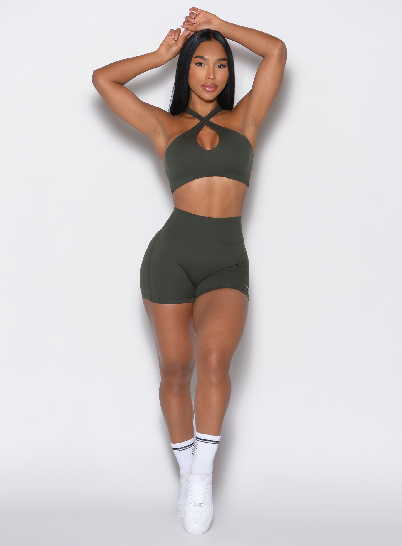 left profile image of model wearing deep ivy (forest green) cross over halter bra and smooth shorts