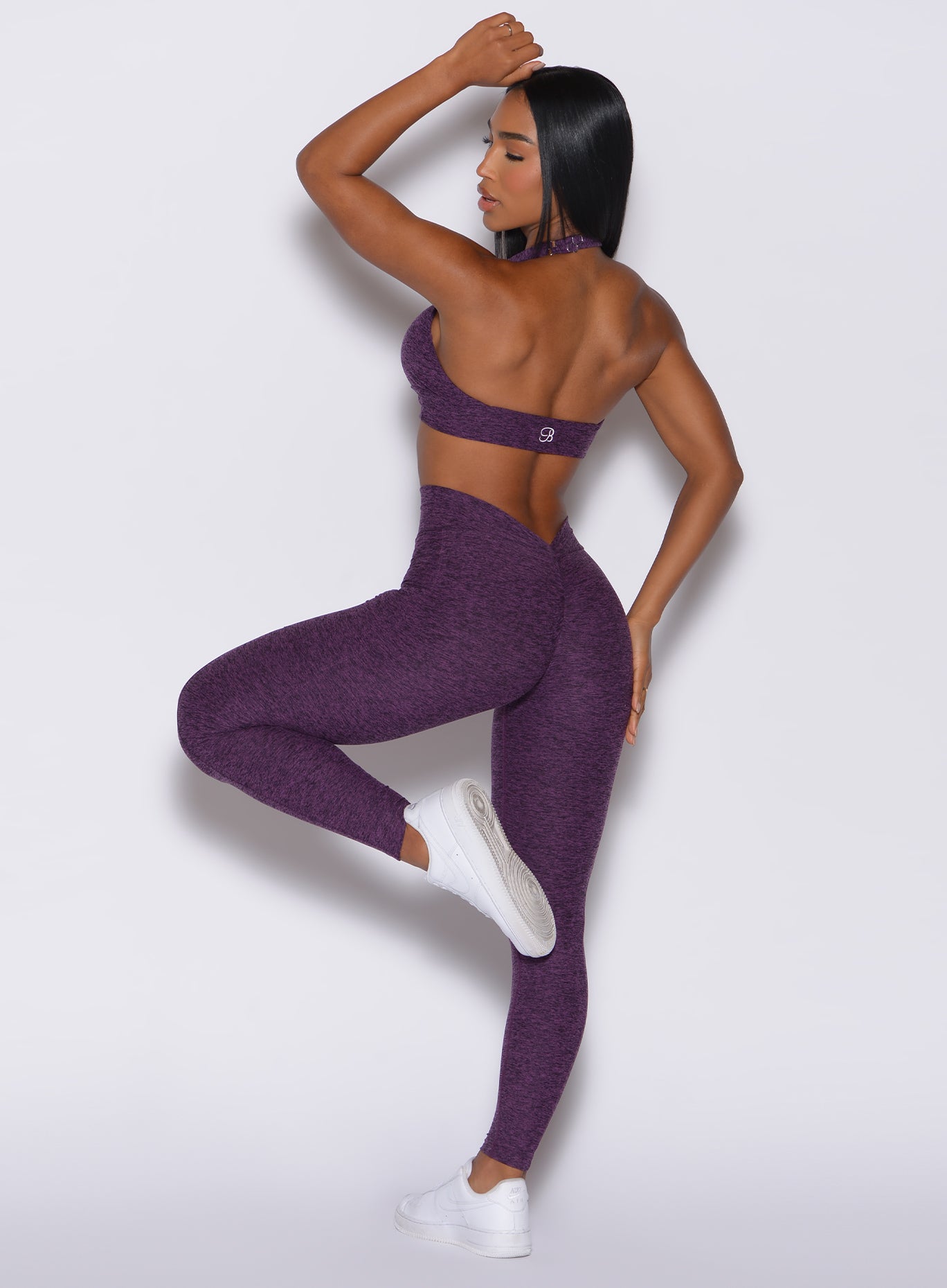 back profile view of a model in our V Back Leggings in purple passion color along with the matching bra